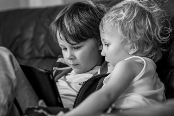 Två barn som tittar på en skärm tillsammans